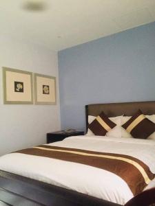 a bedroom with a large bed with brown and white pillows at Subic Bay View Diamond Hotel in Olongapo