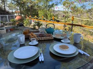uma mesa de vidro com pratos de comida sobre ela em Gazingstars Cottages Agridia 
