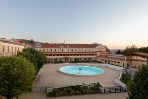 a large pool in a courtyard in a building at Stella Braga Aparthotel in Braga