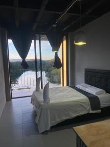 a bedroom with a bed with a view of the water at Nakawe Guatape in Guatapé