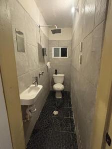 a small bathroom with a toilet and a sink at Hostal Casa Herrera in Guadalajara