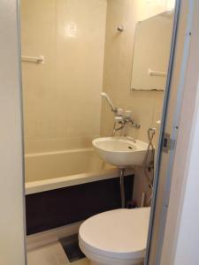 a bathroom with a toilet and a sink and a tub at SunandMoonホテル401 in Tokyo