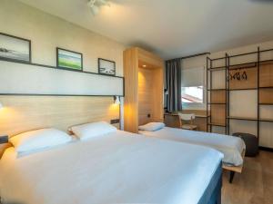 Una habitación de hotel con dos camas y una ventana. en ibis Ciboure Saint-Jean-de-Luz, en Ciboure