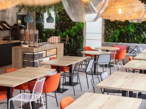 Un restaurante vacío con mesas y sillas de madera. en ibis Ciboure Saint-Jean-de-Luz, en Ciboure