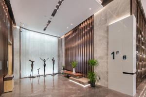 a lobby with three mannequins standing in front of a wall at Atour Hotel Jiading Nanxiang in Jiading +69 photos