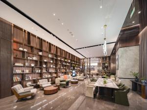 a library with chairs and tables and bookshelves at Atour Hotel Jiading Nanxiang in Jiading