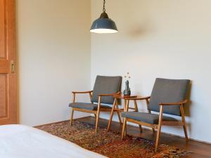 a bedroom with two chairs and a table with a lamp at horn ホルン in Kofu