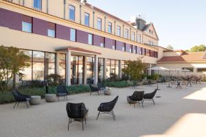 a group of chairs sitting in front of a building at Stella Braga Aparthotel in Braga