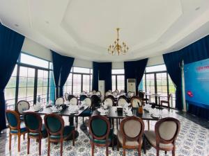 a meeting room with a long table and chairs at Vườn Vua Resort & Villas in Ðồng Phú