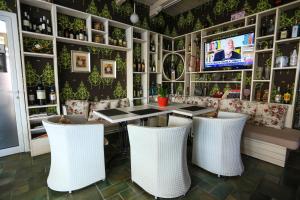 un restaurante con mesa, sillas y TV en Hotel Monarch en Elbasan