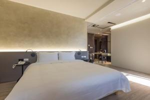 una camera da letto con un grande letto bianco e un tavolo di SUPERB HoTEL a Magong