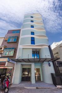 un edificio bianco con uno scooter parcheggiato di fronte di SUPERB HoTEL a Magong