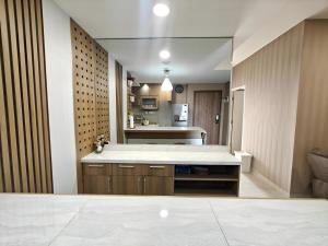 a kitchen with a large island in a room at Stylish 3BR Skandinavia Tangcity Apt Max 12 Guests in Karawaci