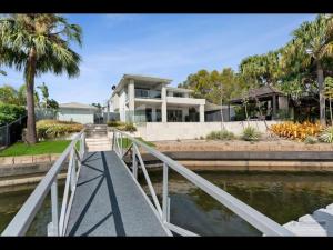 una casa con un ponte sopra un corpo d'acqua di Maison De Vacances a Banksia Beach