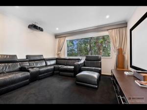 un soggiorno con un divano in pelle e una televisione di Maison De Vacances a Banksia Beach