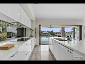 una grande cucina bianca con vista sulla piscina di Maison De Vacances a Banksia Beach