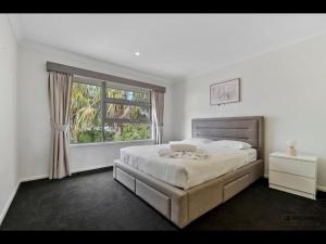 una camera da letto con un letto grande e una finestra di Maison De Vacances a Banksia Beach Altre 23 foto
