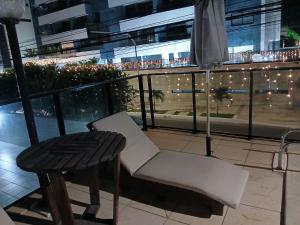 a white chair and a table on a balcony at Alugo Quarto somente uma pessoa in Maceió