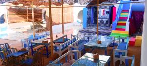a restaurant with blue tables and chairs with food on them at malindy KA nubian houseماليندى كا in Aswan