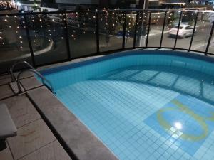a swimming pool on the roof of a building at Alugo Quarto somente uma pessoa in Maceió