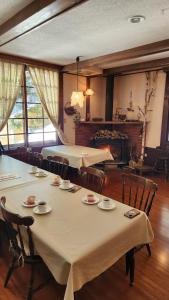 a dining room with two tables and chairs and a large window at Twin Peaks Lodge in Hakuba