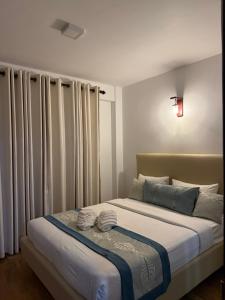 a bedroom with a large bed with white curtains at Nomentano Blue -Luxury Apartments- in Nuwara Eliya