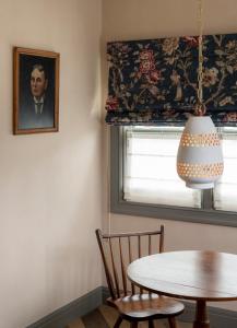 un comedor con una mesa y un retrato de un hombre en Gjelina Hotel, en Los Ángeles