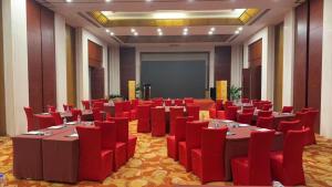 einen Konferenzraum mit roten Tischen und Stühlen und einem Bildschirm in der Unterkunft Greenland Mansion in Shanghai