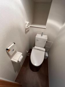 a bathroom with a white toilet and a toilet paper dispenser at Shinbashi Kon Hotel in Tokyo
