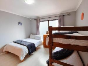a bedroom with two bunk beds and a window at Linaria Beach House in Britannia Bay +16 photos