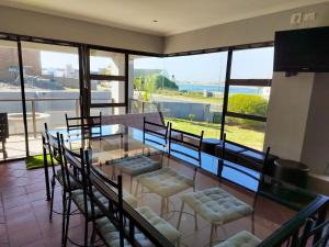 a dining room with a glass table and chairs at Linaria Beach House in Britannia Bay