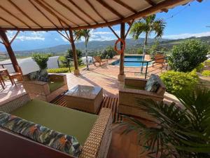 Un patio con mesa y sillas y una piscina. en Glamping de Ensueño con Piscina en Barichara, en Barichara