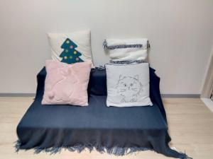 a bed with three pillows and a christmas tree at SunandMoonホテル401 in Tokyo