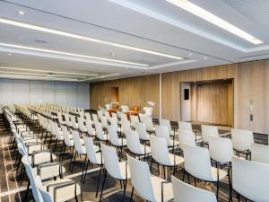 a conference room with white chairs and a podium at Pullman Brussels Centre Midi in Brussels