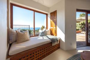a bedroom with a large window with the view of the ocean at The Villino at Cypress Ridge Estate - Stay Waiheke in Onetangi