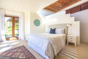 a white bedroom with a bed and a window at The Villino at Cypress Ridge Estate - Stay Waiheke in Onetangi +50 photos