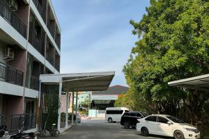 twee auto's geparkeerd op een parkeerplaats naast een gebouw bij Jommalai Boutique Hotel in Ban Nong Chaeng