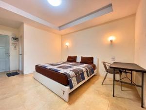 een slaapkamer met een bed en een tafel erin bij Jommalai Boutique Hotel in Ban Nong Chaeng