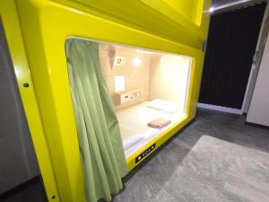 ein kleines gelbes Zimmer mit einem kleinen Bett darin in der Unterkunft Hotel Shin-Imamiya in Osaka