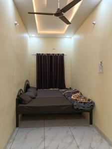 a bed in a room with a ceiling fan at KeshavShree home stay in Ujjain