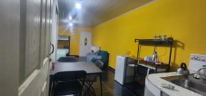 cocina con paredes amarillas, mesa y sillas en Colibriest Bed and breakfast, en La Esperanza