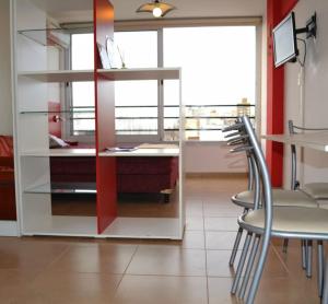 een kamer met stoelen en een bureau met een raam bij Monoambiente en Miramar in Miramar