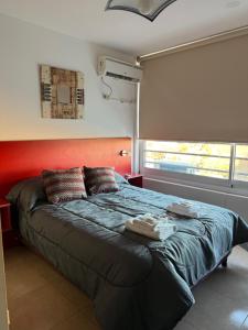 een slaapkamer met een groot bed met een oranje hoofdeinde bij Monoambiente en Miramar in Miramar