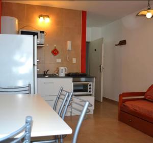 een keuken met een koelkast en een tafel en stoelen bij Monoambiente en Miramar in Miramar