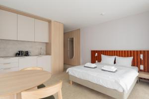 a bedroom with a bed and a table and a kitchen at Hidden Coast - Premium Seaside Apartments with Pool, 2-Minute Walk to the Beach in Łukęcin +34 photos