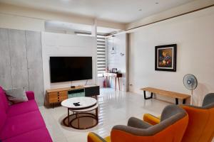 a living room with a couch and a tv at Yun Tian Homestay in Jincheng