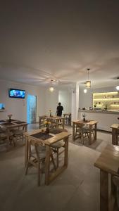 uma sala com mesas de madeira e uma pessoa em uma cozinha em De Vindra Resort em Nusa Penida