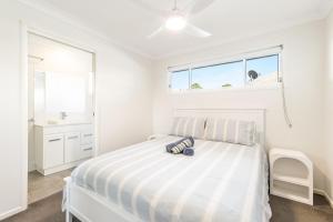 a white bedroom with a bed and a window at Iluka Sea Spray in Iluka