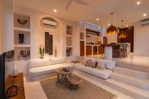 een woonkamer met een witte bank en een tafel bij Villa Le Bijou by BaliSuperHost in Mantaak