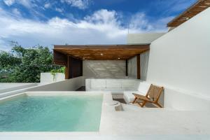 een villa met een zwembad en een stoel bij Villa Le Bijou by BaliSuperHost in Mantaak